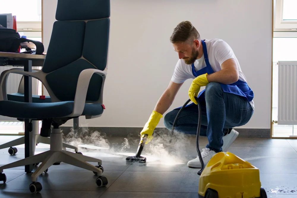 Professional cleaning service person using steam cleaner in office