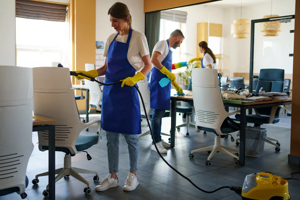 Professional cleaning service person using vacuum cleaner in office